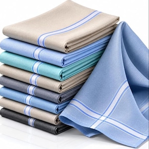 Może przedstawiać: Stos złożonych serwetek z tkaniny w różnych kolorach, w tym beżowym, jasnoniebieskim, turkusowym, szarym i ciemnoszarym. Każda serwetka posiada charakterystyczne biało-niebieskie pasy wzdłuż krawędzi, co nadaje im spójny i jednolity wygląd.