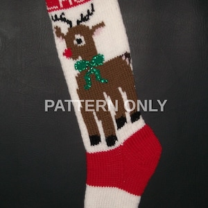 May include: Knitted Christmas stocking with a red and white striped cuff, a green and white striped toe, and a reindeer design. The stocking is personalized with the name "Laura".