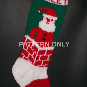 May include: A red and green knitted Christmas stocking with a white Santa Claus design and the name "Harley" embroidered on the top. The stocking has a white cuff and a green toe.