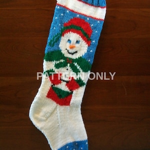 May include: A handmade Christmas stocking with a snowman design. The stocking features a blue cuff, a white band, and a blue body with a snowman wearing a red hat, green scarf, and red mittens. The toe is blue.