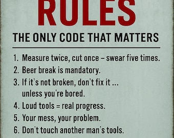 Può includere: Un cartello metallico rettangolare con le parole "GARAGE RULES" in grandi lettere rosse. Sotto, il testo "THE ONLY CODE THAT MATTERS" e un elenco di otto regole umoristiche per un garage. Il cartello ha un aspetto vintage.