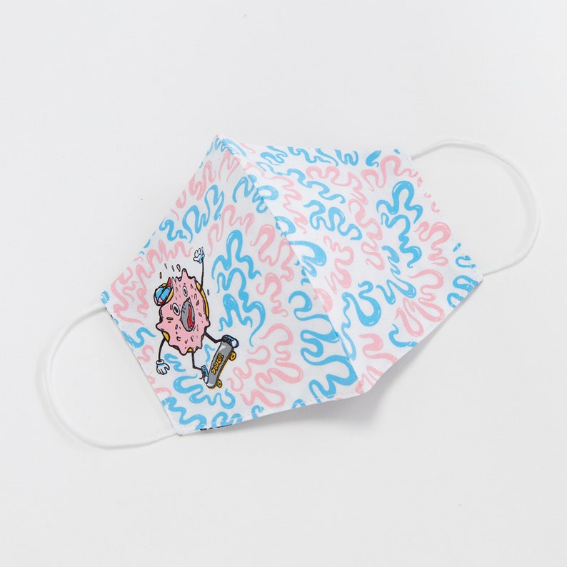 May include: A white face mask with a pink and blue swirl pattern. A cartoon donut with a blue hat and a skateboard is on the mask.