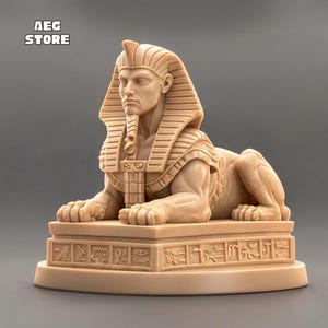 May include: A tan-colored Sphinx statue with a human head and a lion's body. The statue is resting on a rectangular base with hieroglyphs. The text "AEG STORE" is in the upper left corner. The Sphinx is a symbol of ancient Egyptian culture.