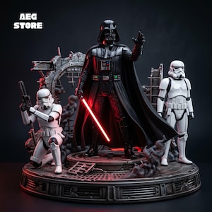 Può includere: Una statua da collezione raffigurante Darth Vader in armatura nera con una spada laser rossa luminosa, affiancato da due stormtrooper in armatura bianca su una base circolare con detriti. Il testo AEG STORE è visibile nell'angolo in alto a sinistra.