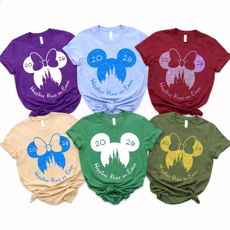 K&ouml;nnte beinhalten: Sechs kurz&auml;rmelige T-Shirts in verschiedenen Farben, jeweils mit einem Mickey Mouse-Silhouetten-Design. Das Design enth&auml;lt die Zahlen "20" und "26", eine Schleife, ein Schloss und den Text "Happiest Place on Earth".