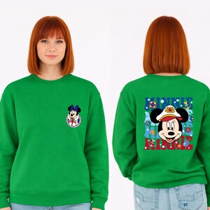 May include: A bright green sweatshirt featuring a Minnie Mouse graphic on the front and back. The front graphic is a small Minnie Mouse in a sailor outfit. The back graphic says "MINNIE" with Minnie Mouse in a sailor hat.