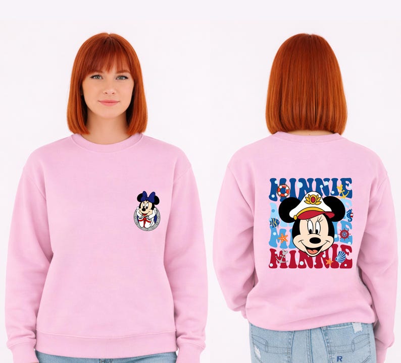 May include: A light pink sweatshirt featuring Minnie Mouse. The front has a small Minnie Mouse graphic. The back has a larger graphic of Minnie Mouse in a sailor hat with the word "MINNIE" in blue and red.