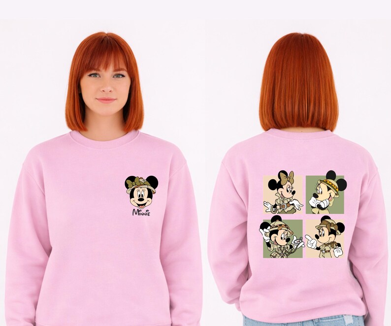 May include: A pale pink sweatshirt with Minnie Mouse graphics. The front displays Minnie in a safari hat, with "Minnie" below. The back features four panels with Minnie in safari attire. The design is a fun, cartoon style.