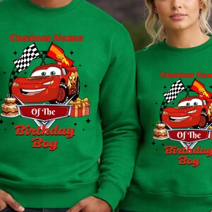 May include: Green sweatshirts with a red Lightning McQueen graphic, checkered flags, and the text "Custom Name" and "Of The Birthday Boy" in red. The design includes a birthday cake and wrapped gifts.