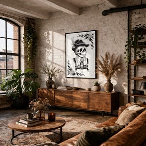 Puede incluir: Una impresi&oacute;n art&iacute;stica en blanco y negro enmarcada que representa un esqueleto con sombrero y tirantes. La obra de arte se exhibe en una sala de estar con un sof&aacute; de cuero, muebles de madera y plantas. La habitaci&oacute;n tiene un estilo r&uacute;stico e industrial.