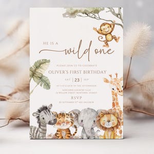 May include: A safari-themed birthday invitation. The design includes illustrations of a zebra, tiger, elephant, and lion. The text reads "He is a wild one" and invites guests to Oliver's first birthday on September 23rd.
