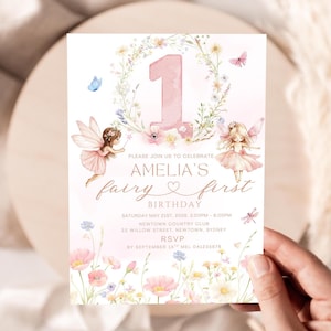 May include: A whimsical invitation for Amelia's first birthday, featuring a pink number one, floral accents, and fairy illustrations. The text reads "Amelia's fairy first birthday" with event details. The invitation is held by a hand.