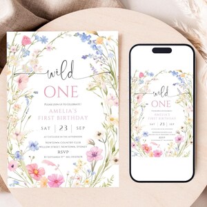 May include: A floral-themed invitation and a smartphone display, both featuring the text "wild ONE" and details for Amelia's first birthday. The design includes watercolor flowers in pink, blue, and yellow, with the date of September 23rd.
