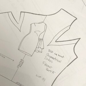 May include: A black and white drawing of a dress pattern with instructions for cutting and attaching the pieces. The pattern is for an asymmetrical dress with a ruffle sleeve. The text on the pattern includes "SID la bust", "Asymmetrical Dress", "Sleeve Ruffle 1", "FRONT Part A", "CUT (1)", "ATTACH PART "B""