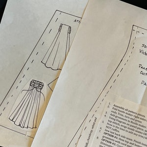 May include: A black and white sewing pattern for a Victorian-style skirt. The pattern includes instructions for cutting and assembling the skirt, as well as a list of materials needed. The pattern is labeled "SD13 Victoria Panels Cut (4) Part".