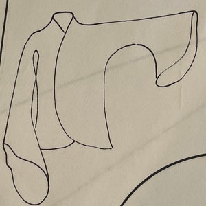 May include: A black and white line drawing of a garment with a long sleeve and a wide collar.