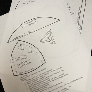 以下が含まれることがあります： フェルト製のトライコーンハットを作るための白黒の図解。図解には、カット、縫製、接着に関する寸法と手順が記載されています。テキストには、「Tricorn Hat」、「Crown」、「Brim」、「Cut (4) outer」、「Cut (4) liner」、「Glue Brim here」、「Attach Part (A)」、「Attach Part (B)」という単語が含まれています。