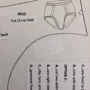 May include: A black and white line drawing of underwear with the text "SD13 Cut (1) on fold" and "back" written on the page. The text "OPTION 2" is written with instructions for sewing the underwear.