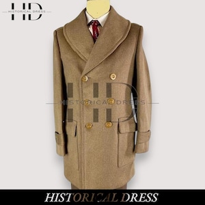 Op de afbeelding: Een dubbelzijdige, bruine wollen jas met gouden knopen en een brede revers. De jas heeft twee voorzakken en een manchet detail op de mouwen. De tekst "HISTORICAL DRESS" staat onderaan de afbeelding.