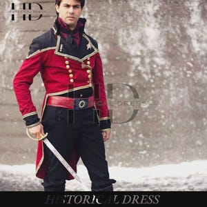 Könnte beinhalten: Eine rot-schwarze Jacke im Militärstil mit goldenen Knöpfen, Goldverzierungen und hohem Kragen, kombiniert mit einer schwarzen Hose und einem roten Gürtel mit Schnalle. Das Set enthält ein dunkelviolettes Halstuch und ein silberfarbenes Schwert.