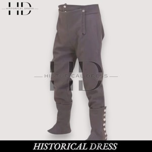 Puede incluir: Pantalones históricos grises con cintura alta y detalles de botones en la parte inferior de la pierna. Los pantalones tienen un diseño único con cierre de botón en la cintura. El texto "HISTORICAL DRESS" está en la parte inferior de la imagen.