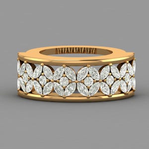 May include: A gold band ring featuring a repeating pattern of marquise-cut and round-cut clear stones. The design consists of four marquise stones arranged in a floral-like motif, separated by small round stones, set within a wide gold frame.
