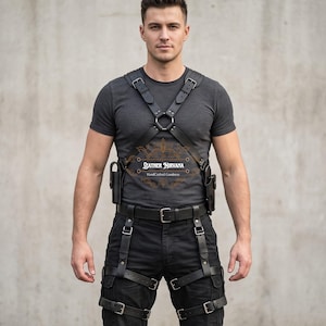 May include: A black leather chest harness with adjustable straps, metal buckles, and a central ring, paired with matching black leather leg straps featuring buckles. The harness includes two side holsters and displays the text Leather Nirvana.