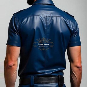 May include: A short-sleeved, navy blue leather shirt with a black belt and dark blue jeans. The shirt has a button-down collar and epaulets. The back of the shirt features the gold text "LEATHER NIRVANA HandCrafted Goodness".