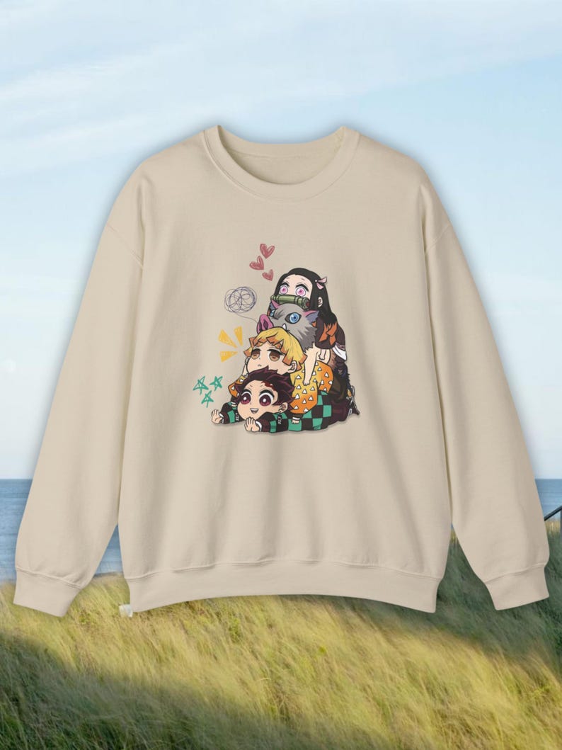 Peut inclure: Sweat-shirt beige avec un graphisme color&eacute; de personnages d'anime. L'illustration comprend trois personnages empil&eacute;s, avec des c&oelig;urs et des bulles de dialogue. Le sweat-shirt a un col rond et des manches longues.