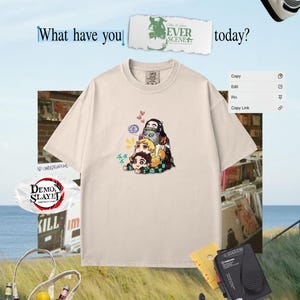 Peut inclure: T-shirt cr&egrave;me avec un graphisme anim&eacute; color&eacute;. L'image comprend le texte "What have you today?" et "Demon Slayer". D'autres &eacute;l&eacute;ments dans l'image incluent un sac fourre-tout, un lecteur de cassettes et des baskets.