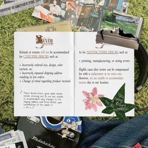 May include: A collection of items on a green surface, including a CD player, a magazine, and a printed page with text about returns. There are also photos, a flower, and a leaf with text that says "You have a right to be happy".