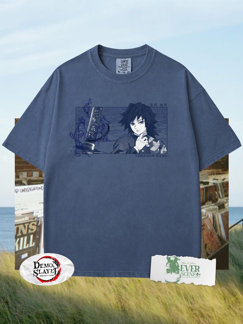 May include: A blue Comfort Colors t-shirt with a rectangular graphic of an anime character and the text "TOMIOKA GIYU". The shirt also features the "Demon Slayer" logo and the text "EVER SCENE".