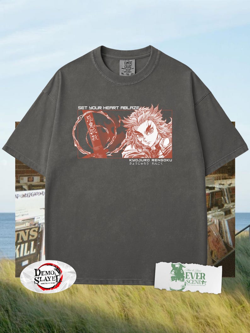 May include: Dark grey t-shirt with a graphic featuring a character illustration and Japanese text. The shirt includes the text "SET YOUR HEART ABLAZE" and "KYOJURO RENGOKU". The shirt is a Comfort Colors XL-TG.