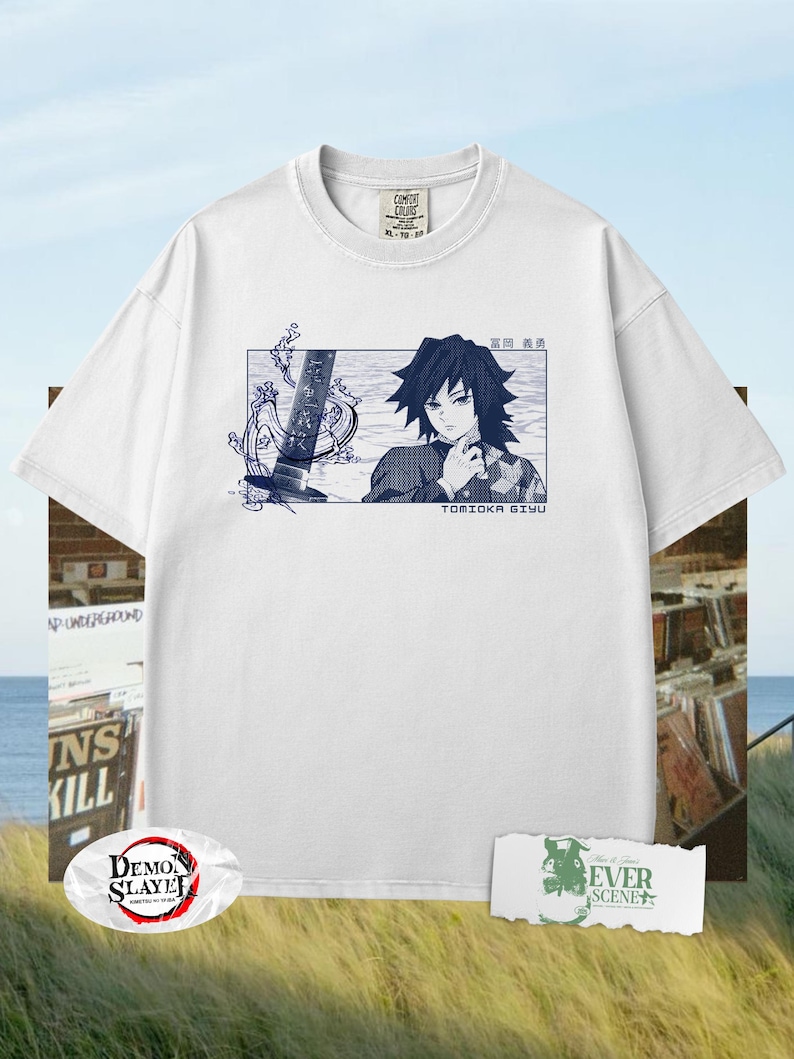 May include: White t-shirt with a blue illustration of Tomioka Giyu from Demon Slayer. The graphic includes Japanese text and a sword design. The shirt has a crew neck and short sleeves. The shirt is a Comfort Colors XL-TG-XXL.
