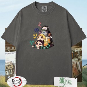 Peut inclure: T-shirt gris fonc&eacute; avec un motif de personnages d'anime empil&eacute;s. Le design pr&eacute;sente des personnages de dessins anim&eacute;s de diff&eacute;rentes couleurs. Le t-shirt a un col rond et des manches courtes. L'&eacute;tiquette indique "COMFORT COLORS".