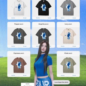 May include: A selection of t-shirts in colours such as white, black, grey, pepper, graphite, ivory, espresso, and khaki. Each shirt displays a graphic design with the word "UR" and a female figure. The image also features a woman in a blue outfit.
