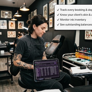 Op de afbeelding: Een tablet met een spreadsheet-interface in een tattoostudio. Een wit tekstvak erboven vermeldt: Track every booking & deposit, Know your client's skin & allergies, Monitor ink inventory, See outstanding balances live. De studio heeft zwarte muren.