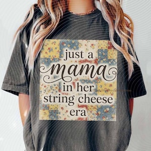 May include: Dark gray t-shirt with a square graphic featuring the text "just a mama in her string cheese era." The graphic has a patchwork design with floral and geometric patterns in yellow, blue, and red.
