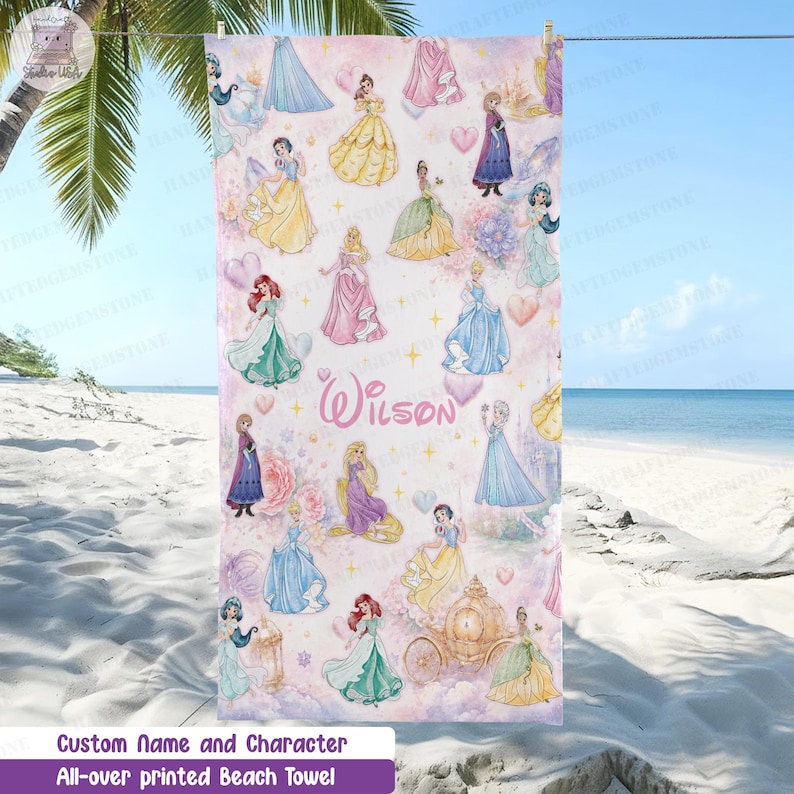 Puede incluir: Una toalla de playa rectangular con un patr&oacute;n repetitivo de varias princesas animadas con vestidos coloridos, un carruaje dorado y corazones sobre un fondo rosa claro. El nombre Wilson est&aacute; impreso en letra cursiva rosa en el centro.
