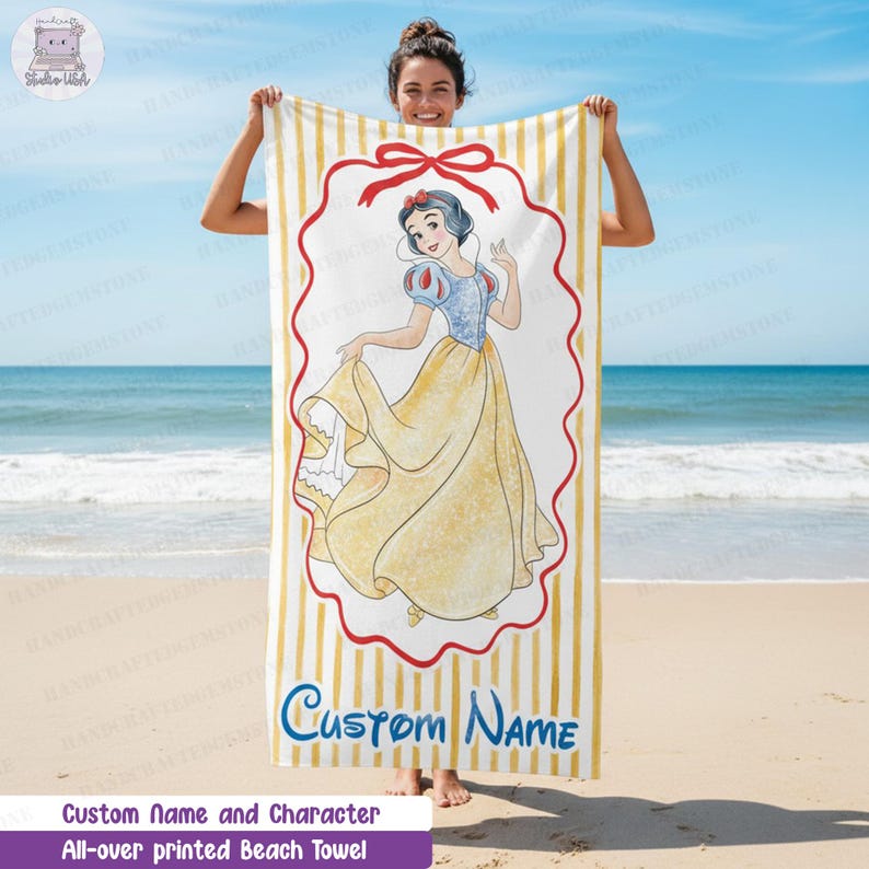 Puede incluir: Una toalla de playa rectangular con un patr&oacute;n de rayas verticales amarillas y blancas. En el centro, un gr&aacute;fico de Blancanieves est&aacute; dentro de un marco rojo festoneado con un lazo rojo. El texto Custom Name aparece en azul en la parte inferior.