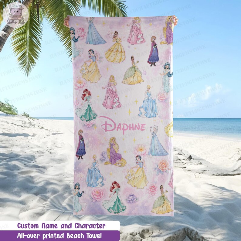 Puede incluir: Una toalla de playa rectangular con un patr&oacute;n repetitivo de varias princesas ilustradas con vestidos coloridos sobre un fondo rosa claro y blanco con estrellas doradas y rosas. El nombre Daphne est&aacute; impreso en rosa en el centro.