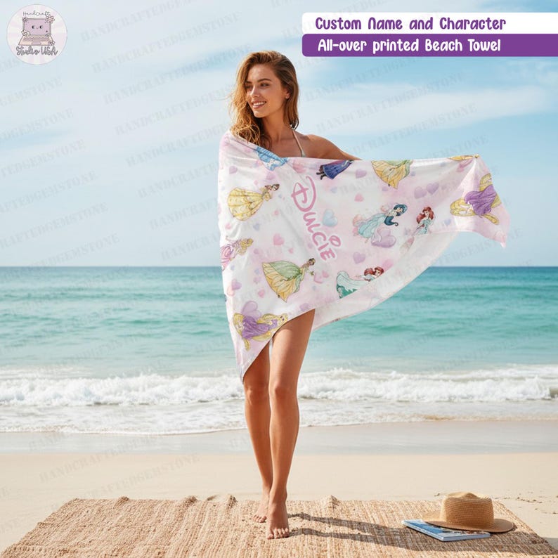 Puede incluir: Una toalla de playa blanca con un estampado integral de varias princesas de dibujos animados y corazones rosas. La toalla muestra el nombre personalizado Dulcie en una fuente cursiva rosa estilizada. La tela es ligera y rectangular.