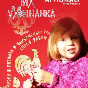 May include: A child in a pink sweater is crafting with paper against a red backdrop. The image includes the text "MY VYCINANKA" and a rooster illustration. The image is labelled "USA, Maryland / 2025."