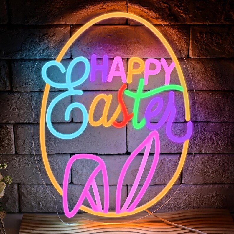 May include: A neon sign in the shape of an egg with the words "Happy Easter" in colorful neon lights. The sign also features neon bunny ears. The sign is mounted on a brick wall.