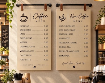 May include: Two rectangular cream-colored menu boards with black text and graphics, suspended by black metal rods and brown leather straps. The left board lists coffee items, while the right board lists non-coffee beverages with prices.