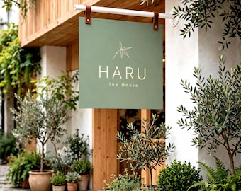 May include: A square, sage green hanging sign with brown leather straps attached to a white horizontal bar. The sign features a thin white line drawing of a bamboo leaf above the text HARU Tea House in a clean, white, sans-serif typeface.