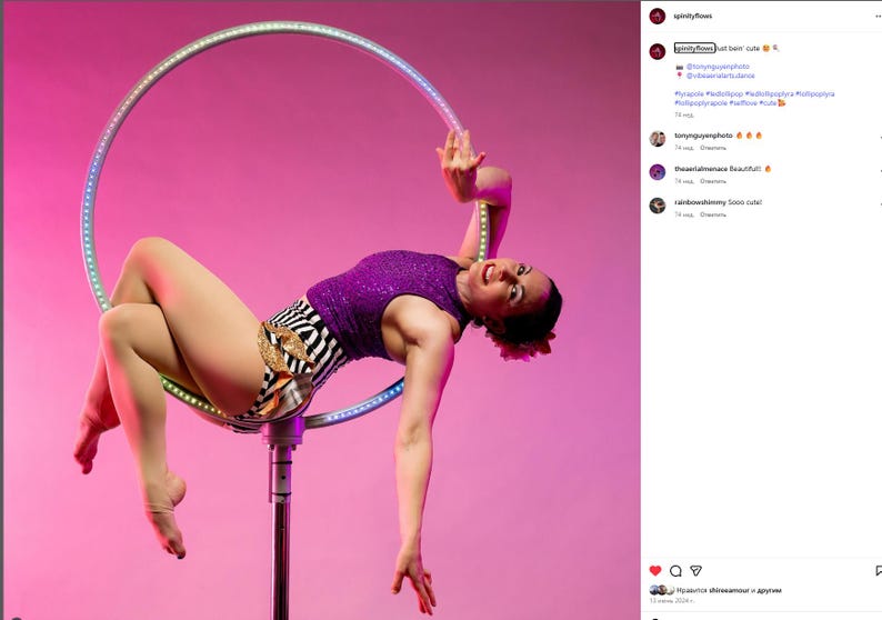 Peut inclure: Une femme v&ecirc;tue d'un haut &agrave; paillettes violet et d'un short z&eacute;br&eacute; pose sur un grand cerceau lumineux sur fond rose. Le cerceau est suspendu &agrave; un poteau, et la femme effectue une danse a&eacute;rienne. L'image est bien &eacute;clair&eacute;e et capture un moment d'athl&eacute;tisme.