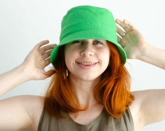 Sombrero Panamá verde con detalle de perforaciones para mujer, práctico sombrero tipo cubo para aventuras de verano.