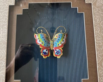 Gran adorno de mariposa de cloisonné en un marco decorativo tipo caja.