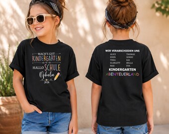 Könnte beinhalten: Ein schwarzes T-Shirt mit einem Front-Aufdruck "MACH'S GUT KINDERGARTEN HALLO SCHULE Ophelia 2026" und einem Bleistift-Symbol. Die Rückseite zeigt den Text "WIR VERABSCHIEDEN UNS" gefolgt von einer Namensliste und "KINDERGARTEN ABENTEUERLAND".